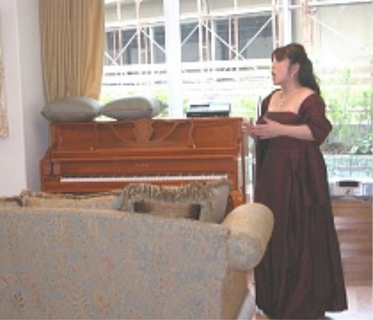 ピアノの前に立つ女性