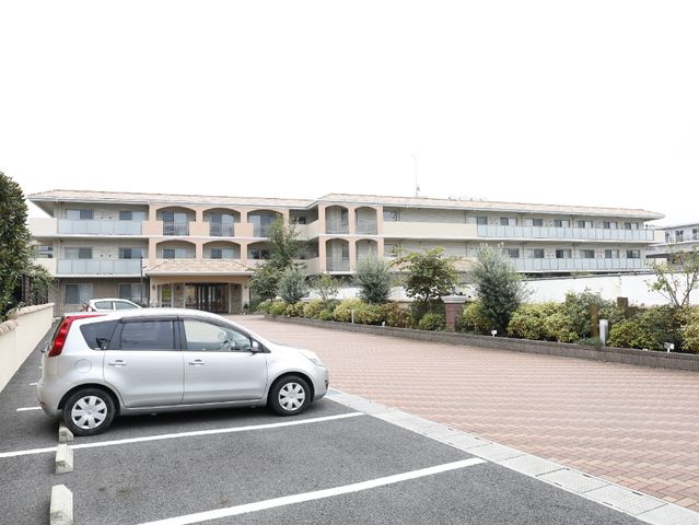 広々とした施設の外観 駐車場 落ち着いた色合いの建物が印象的です。広い駐車場が完備され、来訪しやすい環境が整っております。