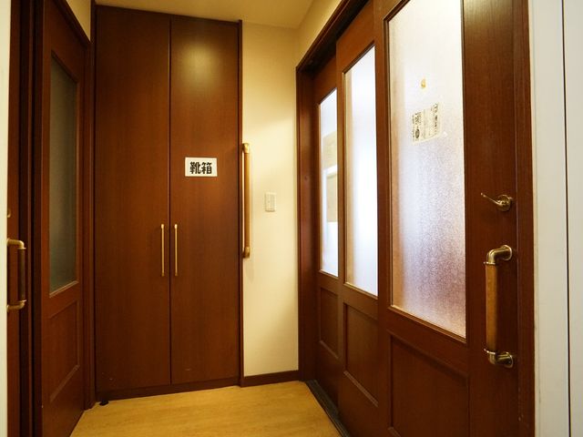 清潔な廊下の扉 廊下 手すりが設置された落ち着いた色合いの廊下。利用者の移動をサポートし、安全な環境を整えています。