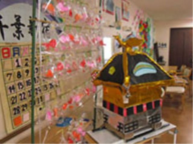 手作り祭り飾りの廊下 お神輿 手作りの祭り飾りが華やかな廊下があり、創造性豊かな環境で働けることを感じられます。ユニークな職場文化を大切にしている様子が伝わります。