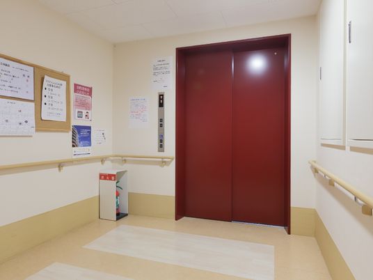 赤い扉と掲示物の廊下