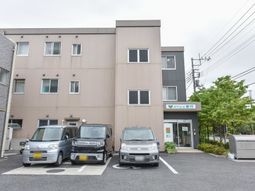 茶色の建物と駐車場外観