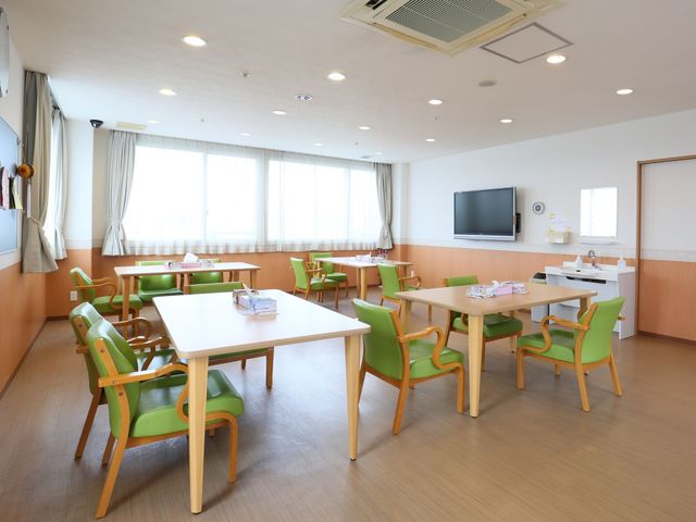 広々とした明るい食堂 共有スペース 座り心地の良さそうな緑色の椅子が並ぶ、ゆとりある食堂です。共有スペースでの交流やリラックスタイムを想像させる設計となっています。