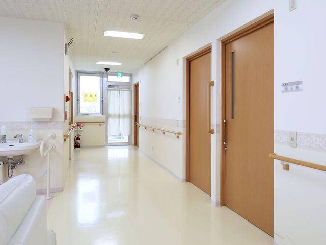清潔な病院の廊下 廊下 手すりが設けられた廊下は、床が照り輝く清潔感があり、安全に歩行できる環境が整っています。扉や洗面所の配置も、使いやすさを考えた設計になっております。