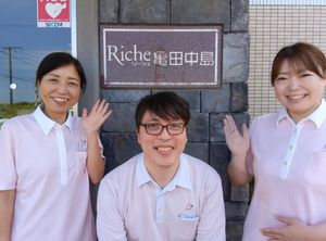看板の前で微笑むスタッフ