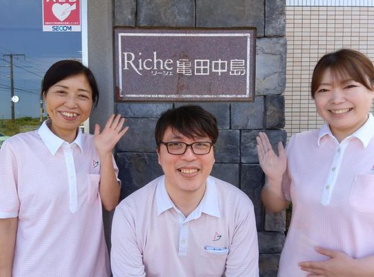看板の前で微笑むスタッフ
