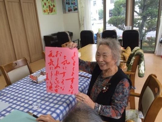笑顔で作品を披露する高齢者