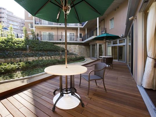 木製デッキとパラソルの中庭