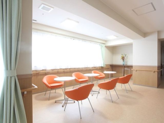 明るい食堂のテーブルと椅子 共有スペース 開放感ある食堂で、橙色の椅子が明るさを演出しています。余裕をもった配置で快適にお食事ができる設計となっています。