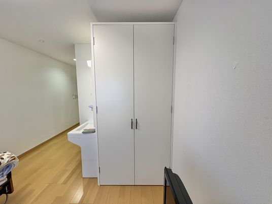 白い収納戸と洗面台の廊下