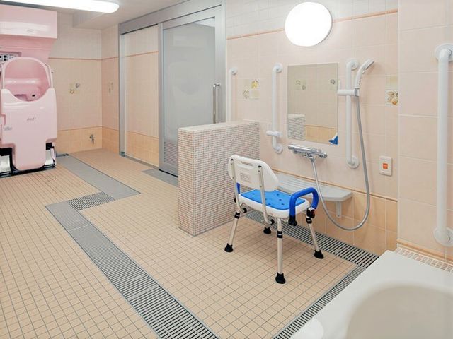 バリアフリーのケア浴室 温もりのある浴室 ケアを受ける方の安全と快適さを考えた広々とした浴室です。手すりやシャワーチェアも完備しております。