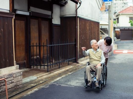 車椅子の老人と職員