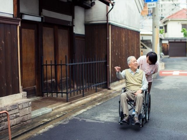 車椅子の老人と職員