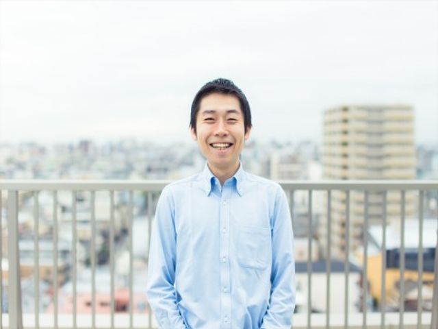 笑顔のスタッフと背景の街並み