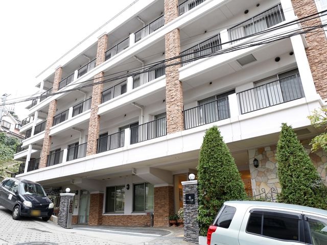 白亜の建物とエントランス 外観 開放的なエントランスは明るく、訪れる人を温かく迎え入れます。車椅子の方も安心してアクセスできる構造になっております。