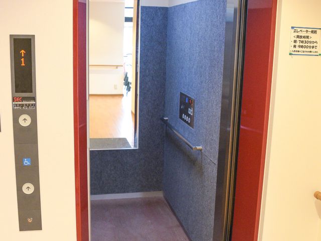 赤い枠のエレベーター エレベーター 手すり付きのエレベーターで安全性が確保されており、どなたでも快適に移動できる設計となっています。