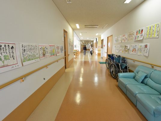 広々とスペースのとられた廊下にはソファや車椅子が置かれている。壁には手摺りが設置され、様々な掲示物がはられている。