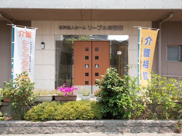 エントランスとお花の風景 玄関 温かみのある色合いのエントランスです。入口には鮮やかなお花が並び、訪れる方をやさしく迎えています。