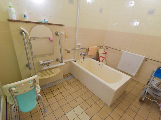 洗い場は入居者様が体を洗ったり、頭を洗うのに十分なスペースを設けている。手すりなどが壁、浴槽に設置してある安全設計である。