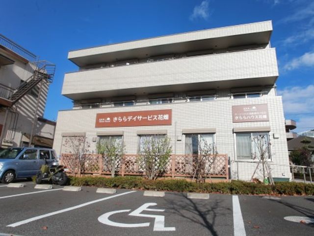 白い建物の外観 外観 明るく開放的な外観のこの場所は、ゆったりとした時間を過ごせる環境が整っており、ここでのお仕事を通じて多くの方々のサポートに携わることができます。