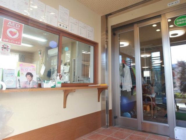 受付スタッフと観葉植物 受付 笑顔で対応する受付スタッフが見えます。心地よい印象の入口で皆様をお迎えします。