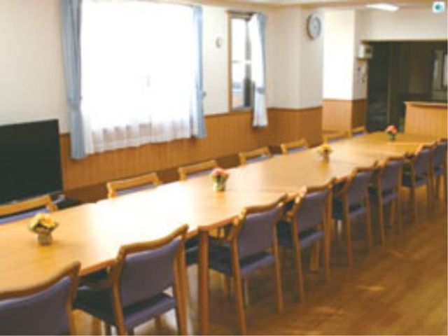 テーブルのある食堂 レクリエーション ゆったりした椅子が並ぶ明るい食堂では、共に食事の時間を楽しむことができます。窓からは自然光が入り、温かな雰囲気を感じられる空間です。
