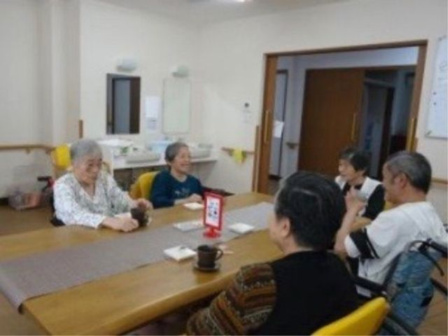笑顔で会話する居室 日常 ゆったりとした居室で、利用者同士が笑顔で会話を楽しんでいます。そこは心温まるコミュニケーションの場となっています。