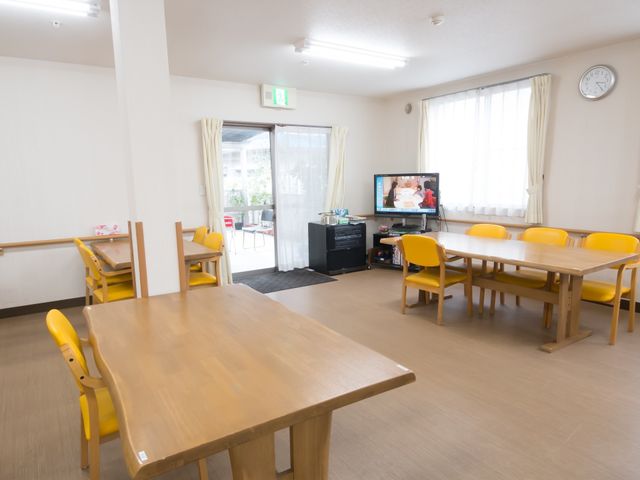 広々とした共用食堂 リビング ゆったりとしたダイニングルームです。テレビが置かれ、椅子とテーブルも配置されており、食事やコミュニケーションの場として利用できます。