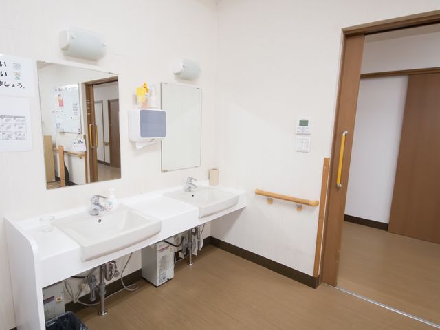 手すり付き洗面台 洗面台 手すりが付いており、安全に支えながらご利用いただける洗面スペースです。清潔感のあるデザインが心地よい環境を演出しています。