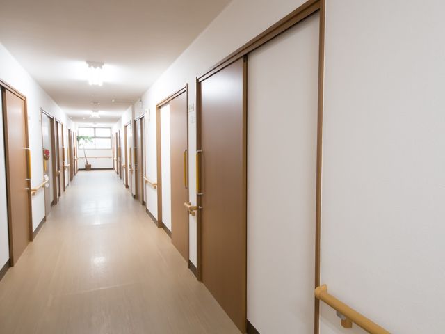 清潔な施設の廊下 共用廊下 広々とした廊下は清潔感があり、ゆったりとした時間が流れている様子です。スタッフの方々が活動しやすい環境が整っています。