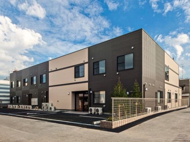 モダンなデザイン外観 外観 落ち着いた色合いの建物で、広々とした駐車スペースがあります。働きやすい環境をお探しの方にぜひ見ていただきたいです。