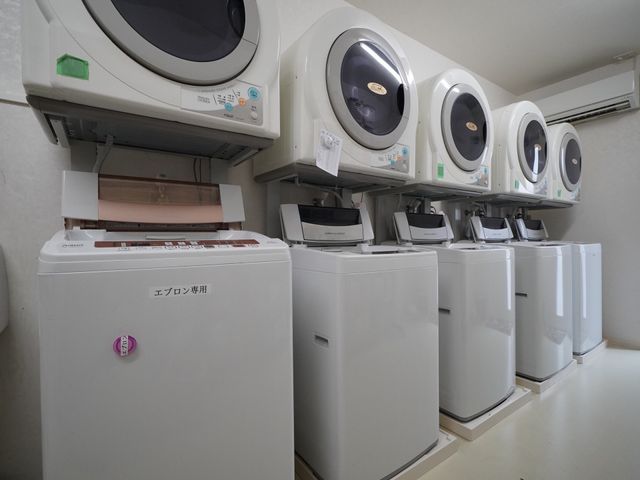 清潔な洗濯機群 洗濯室 コインを利用する洗濯機が並んでおり、清潔感のある設備で皆さまの日々の生活をサポートいたします。