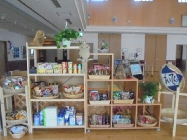 お菓子棚のあるロビー ロビー   木の棚にお菓子や日用品が並び、すっきりとした明るいロビーです。来訪時の待ち時間にも使いやすそうな雰囲気です。