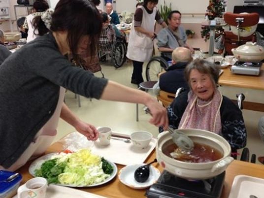 笑顔で食事の介助をするシーン