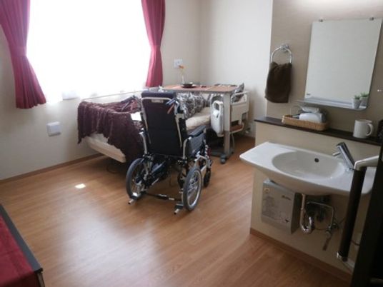 車椅子とベッドのある居室