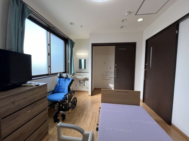 居心地の良い居室 居室 広々とした明るい個室です。ベッドや車椅子も配置されており、快適な日々を過ごせる環境が整っています。