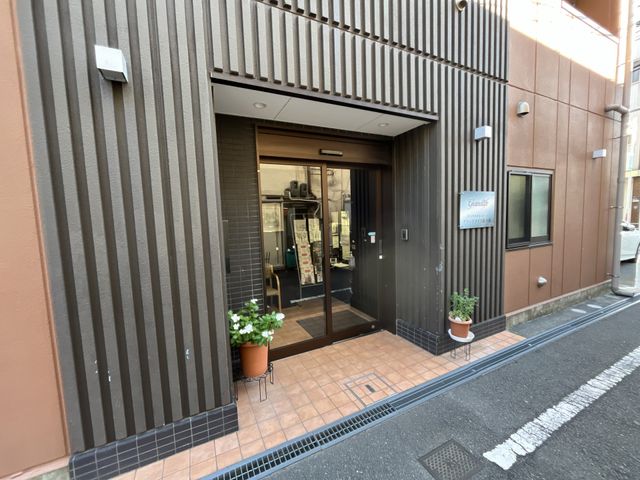 エントランスの様子 エントランス 落ち着いた色調のエントランスでは、温もりを感じる植栽がお出迎えします。ガラス扉からは明るさが伝わり、安心して足を踏み入れられる空間です。