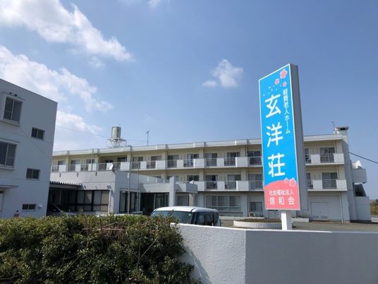 青空と施設看板の外観  