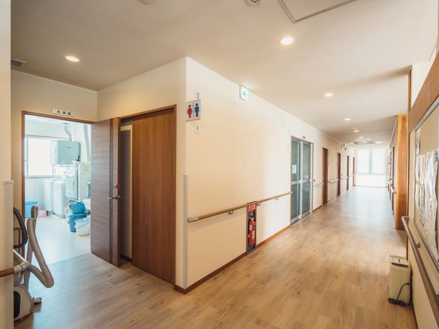 広々とした明るい廊下 廊下 手すりが設置されており、床も滑りにくく、安全に配慮された廊下です。壁面には掲示物があり、コミュニケーションの場を提供しています。