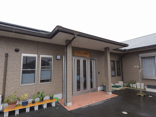 入口のあるきれいな建物 玄関 ご覧の通り、広々とした入口がお出迎え。落ち着いた色合いの建物は、働く環境としても心地よい雰囲気を提供しています。