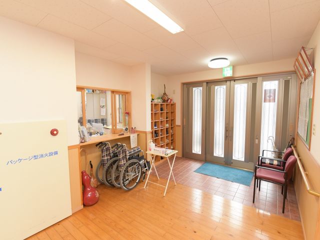 明るいエントランスと車椅子 玄関 明るく開放的なエントランスです。多様なニーズに対応できる車椅子も備え、快適な来訪が可能です。