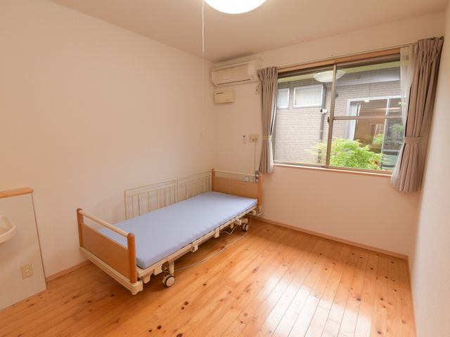 明るい個室の居室 居室 床の木目が温かみを感じさせる個人の居室です。ゆったりと過ごせる空間が設けられており、快適な日々をお過ごしいただけます。