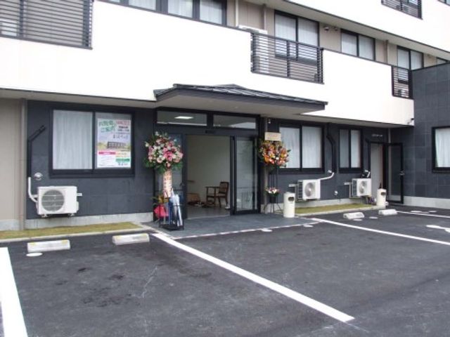 エントランスと駐車場 エントランス ゆっくり歩ける広々としたエントランスは、訪れる皆様を明るく迎えます。花々が飾られ、温かみのある雰囲気が漂っています。