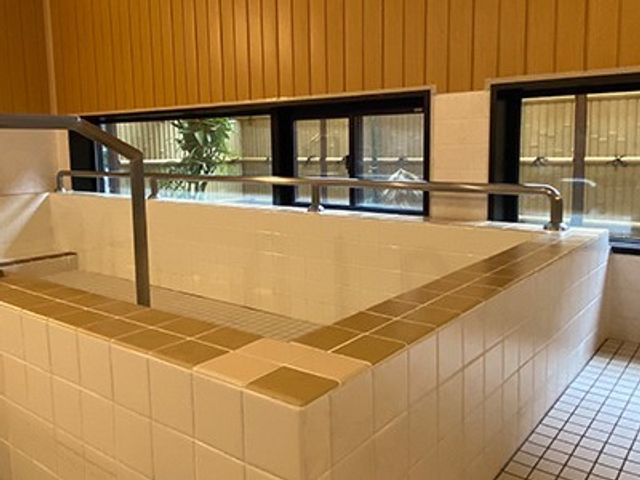浴室の手すり付き洗い場 浴室   手すりが設けられた洗い場で、段差を抑えたつくりです。清掃しやすいタイル張りで、落ち着いて使いやすそうです。
