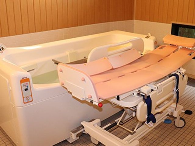 入浴用リフト付き浴室 浴室   木目調で落ち着いた浴室です。入浴用リフトが備わっており、介助しやすい環境がうかがえます。