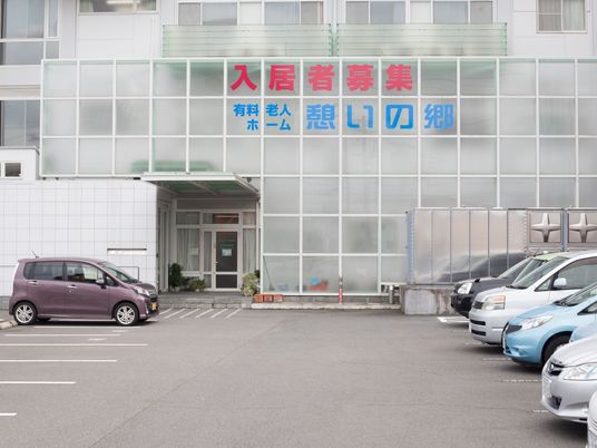 駐車場と入口のある外観