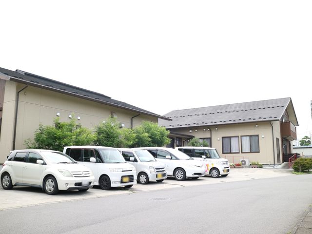 ゆったりした外観の建物 駐車場 広々とした駐車スペースが整っており、アクセスしやすい立地の建物です。閑静な地域に位置し、安心してお過ごしいただけます。