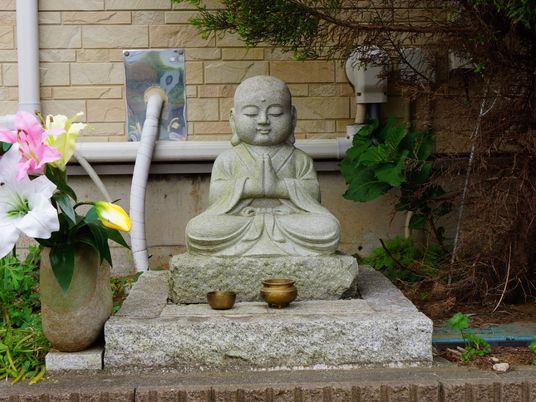 石造りの仏像と花