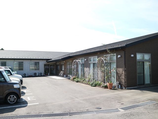 一戸建てタイプの施設外観 外観 庭には植物が配され、落ち着いた雰囲気のエントランスが迎えます。こちらでのお仕事では穏やかな環境を提供できます。