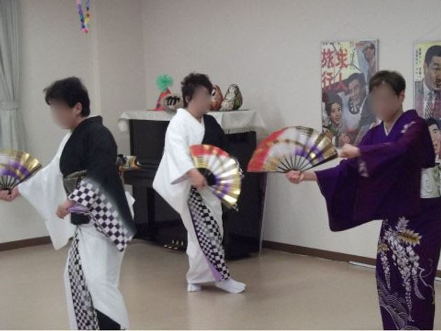 和風衣装を着た人々の趣味活動 イベント 着物に身を包み、色とりどりの扇子で踊る方々が、充実したひと時を過ごしています。文化的な趣味活動も楽しめる環境です。